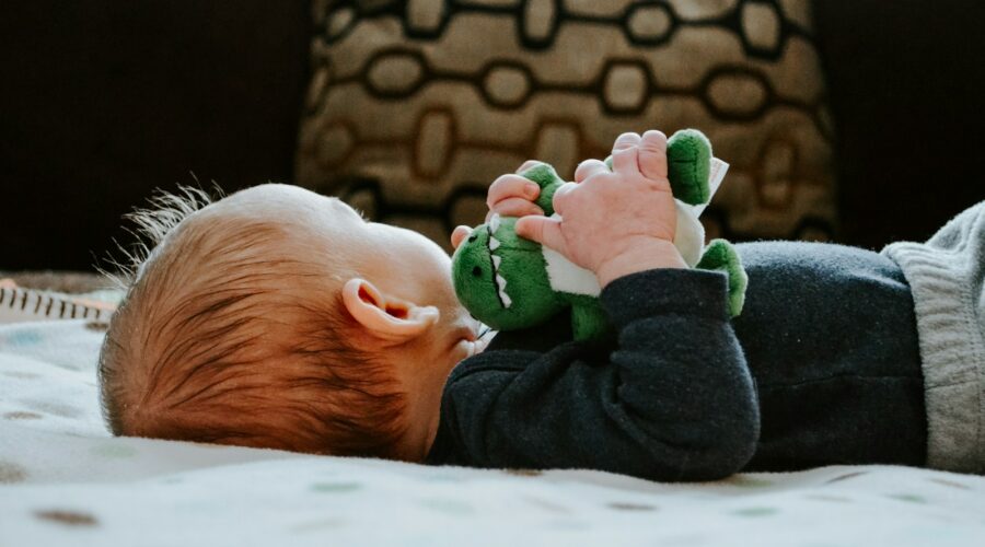 baby lying on white bed