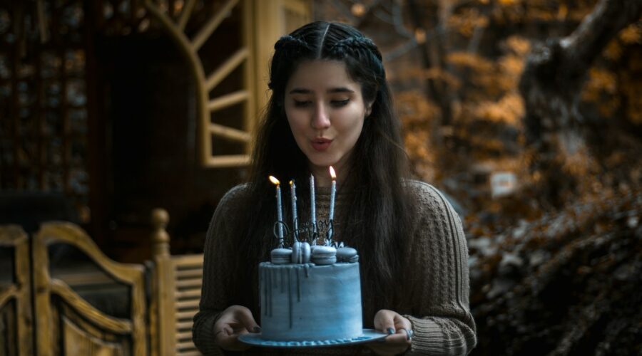 a woman holding a cake with lit candles