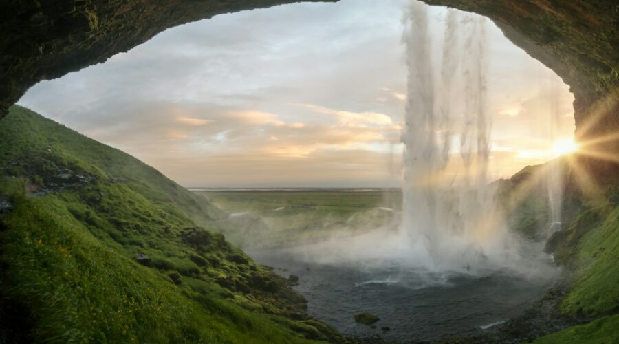 waterfalls near cave at daytime