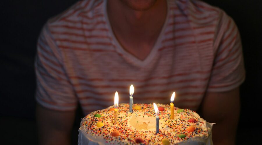 person holding white icing-covered cake