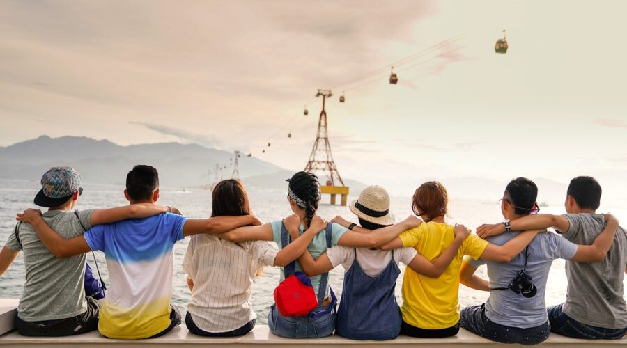people holding shoulders sitting on wall