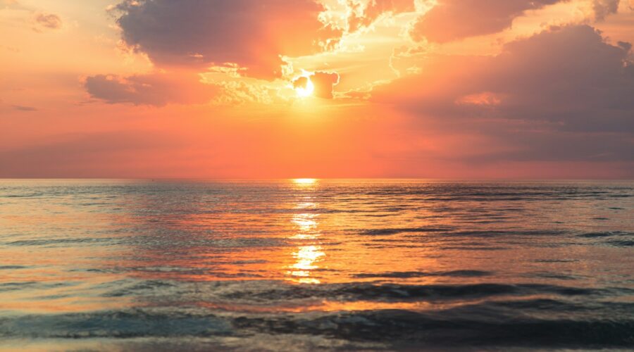 sea under white clouds at golden hour