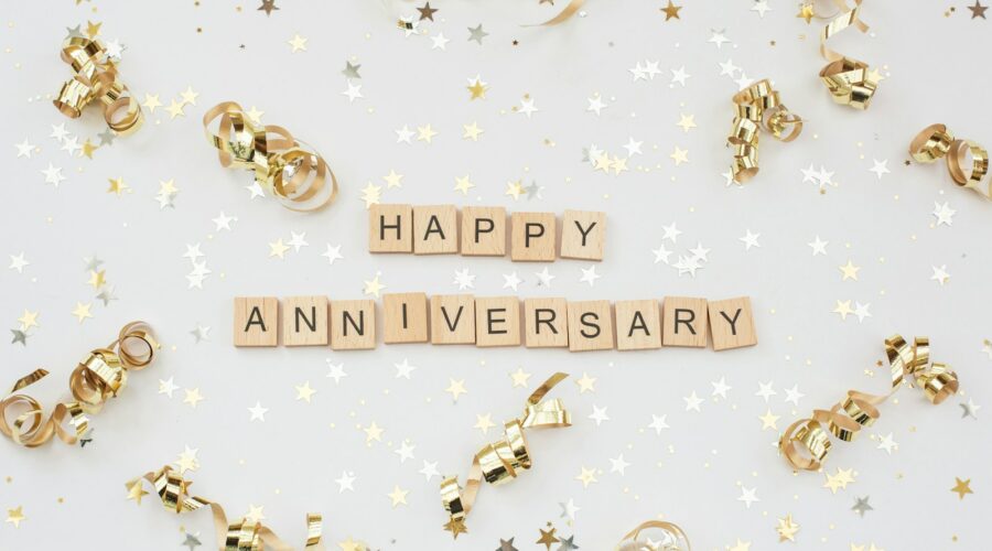 a happy anniversary spelled with scrabbles on a white background